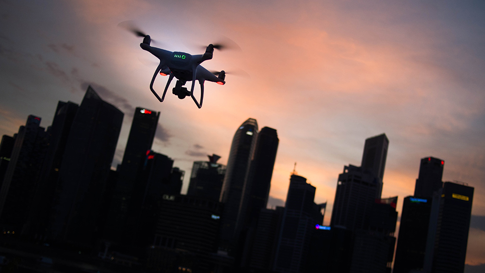 Drone på raud kveldshimmel med skyskraparar i bakgrunnen.