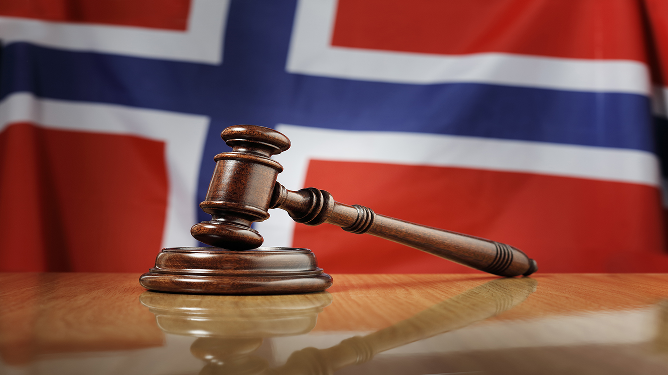 Illustration photo of a justice hammer with a Norwegian flag in the background. 