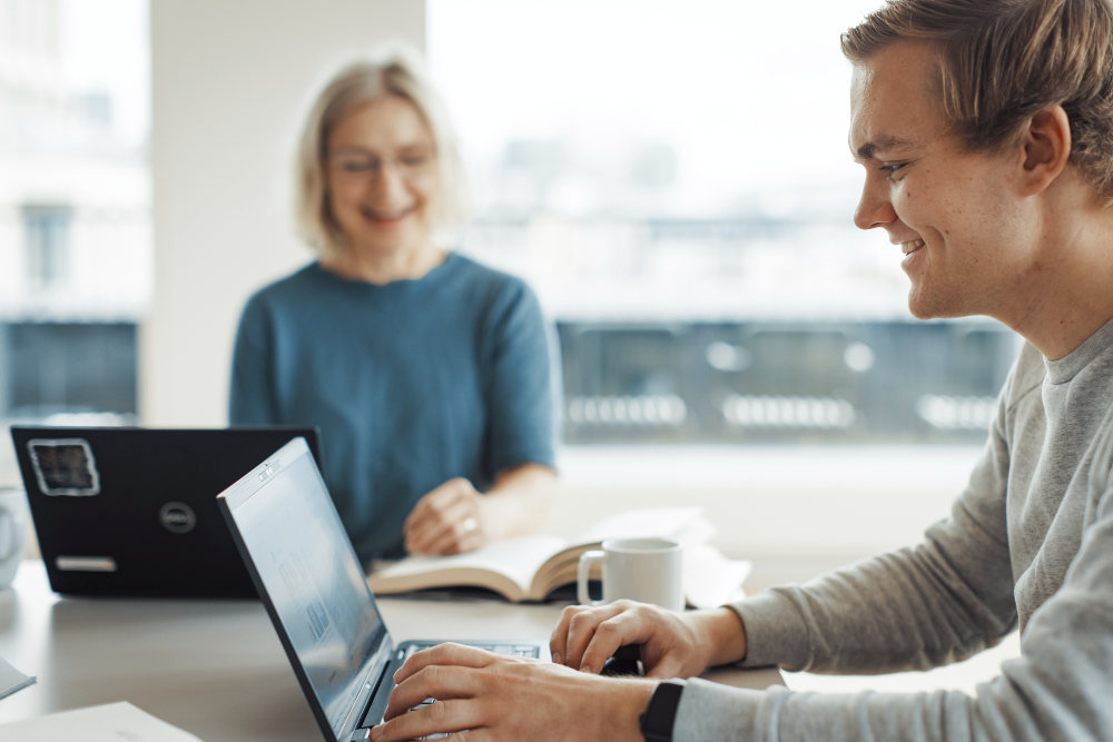Bildet kan inneholde: datamaskin, smil, hånd, personlig datamaskin, bord.