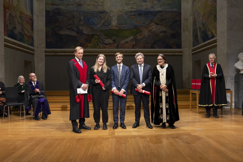 Tre doktorander flankert av rektor og en instituttleder.