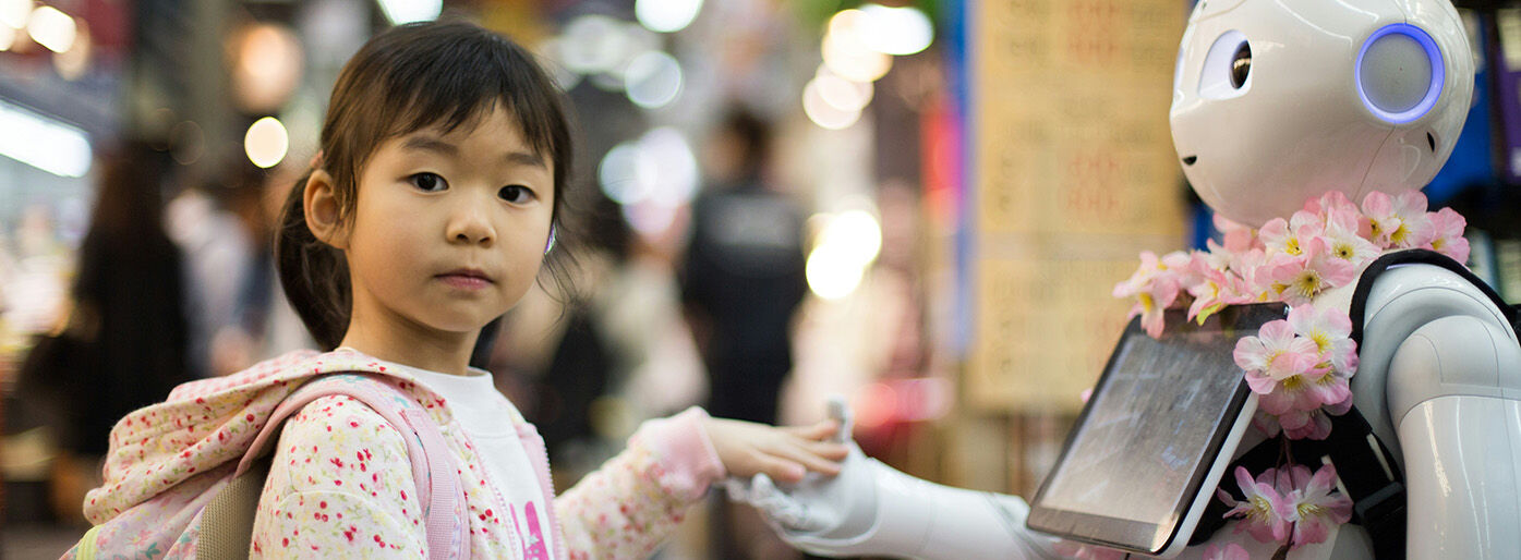 Snapshot of child holding robots hand