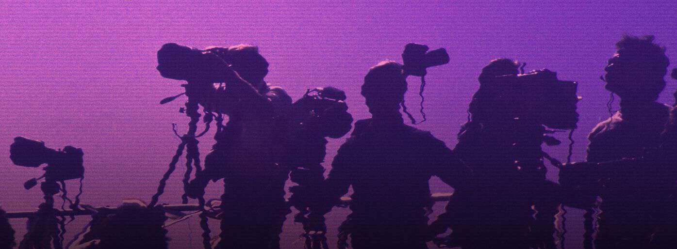 Silhoutte of press photographers at an event.