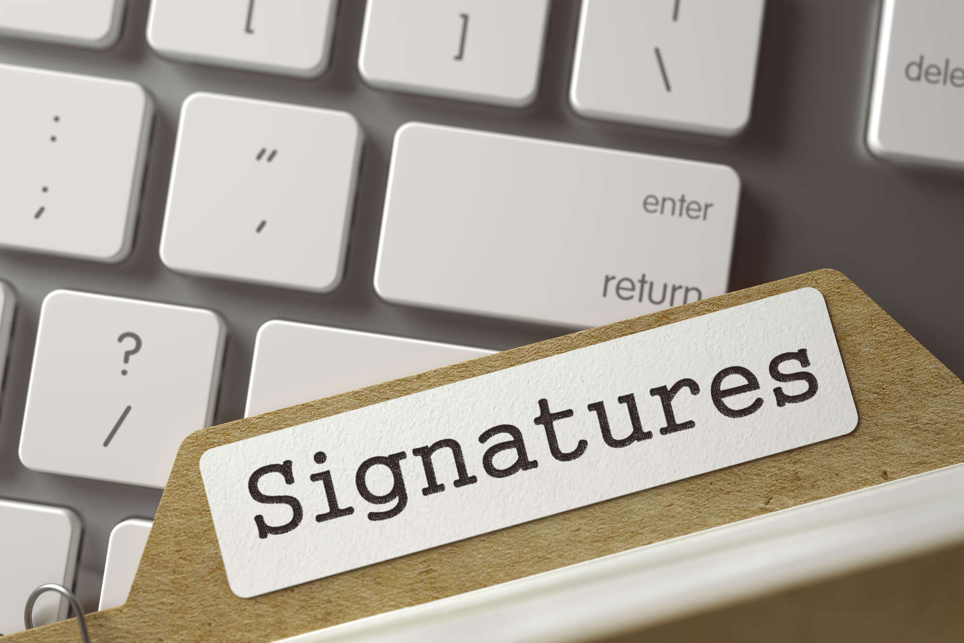 Tastatur med en mappe lagt oppå, med tittel: Signatures.
