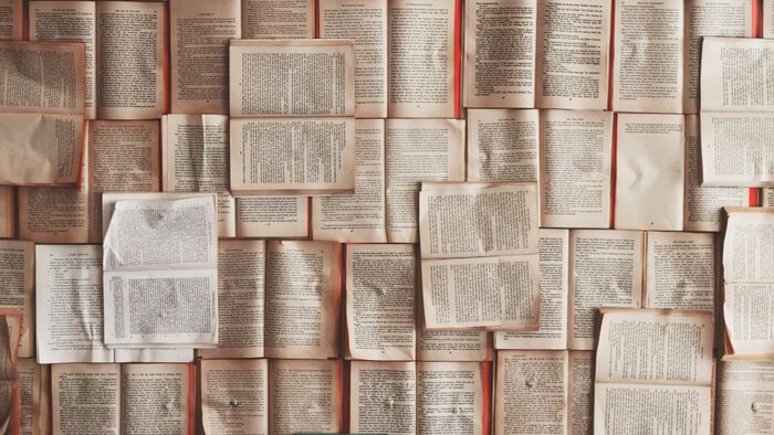 A photo of a lot og open books spread out on a flat surface