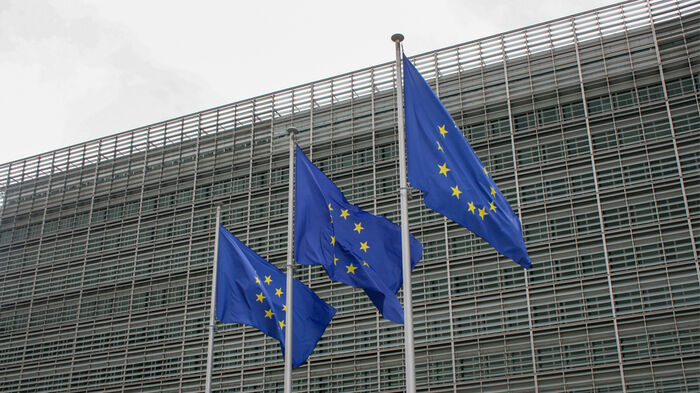 Three EU-flag in front of the EU building. 