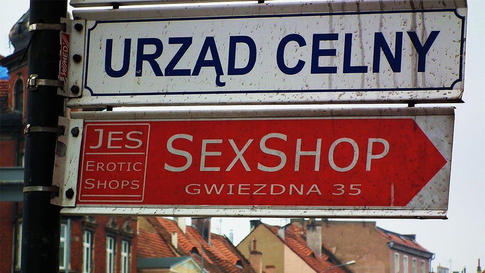 The image shows a road sign with the text "sex shop"