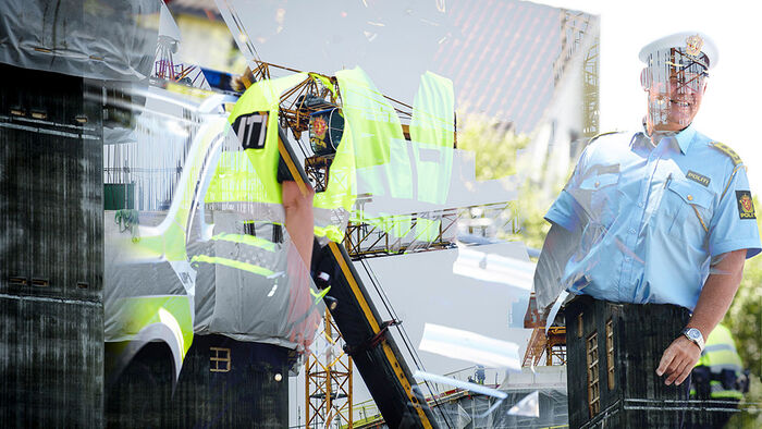 Bildet viser en mann i gul politivest og en politimann i uniform. I bakgrunnen er det et arbeidsanlegg.