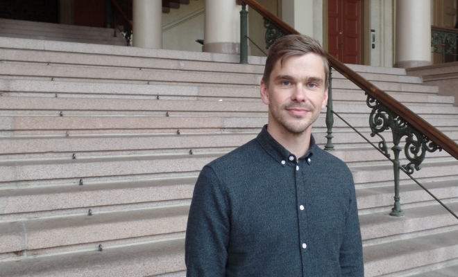 Thomas Anton Sandøy foran trappen inn til universitetets aula.