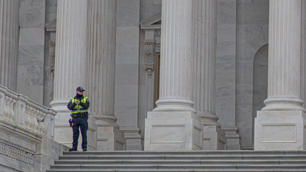 A policeman standing guard in front of the US Capitol