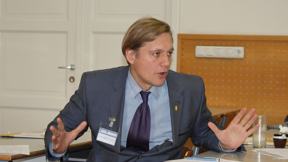 Vaidotas Vaicaitis, seated behind a desk, speaking with open hands.