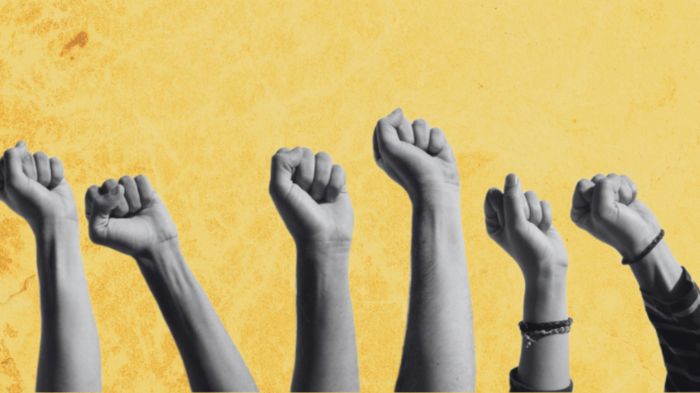 Several firsts are risen in the air, worn out yellow background.