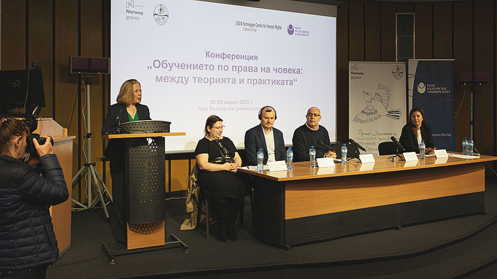 Image of five people, four of which are part of a panel and one of which is presenting. They are in front of a screen with a presentation with Bulgarian text.