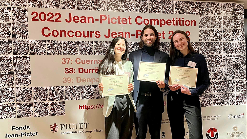 Image of the three UiO students who participated, in front of a competition banner, holding certificates
