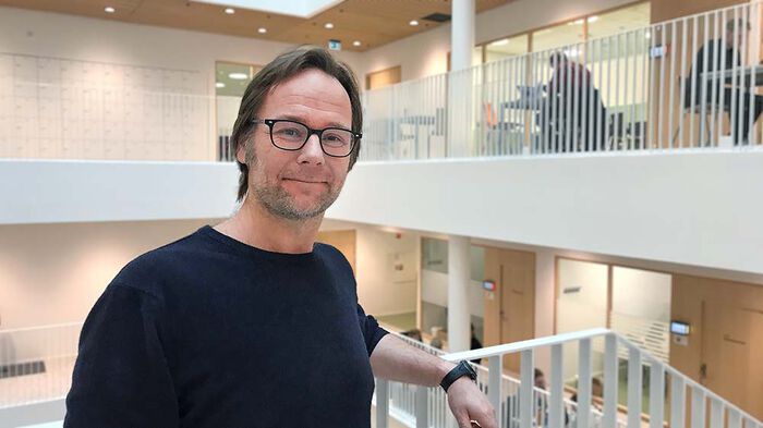 Tarjei Bekkedal står i trappen i bygget Domus Juridica