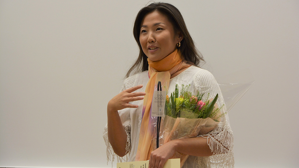 Bilde av jusstudent Celine Song Mee Nilsen under utdelingen av studentenes inkluderingspris i 2023. Hun holde tulipaner i hånden. 